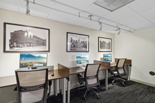 a conference room with desks and chairs and pictures on the wall