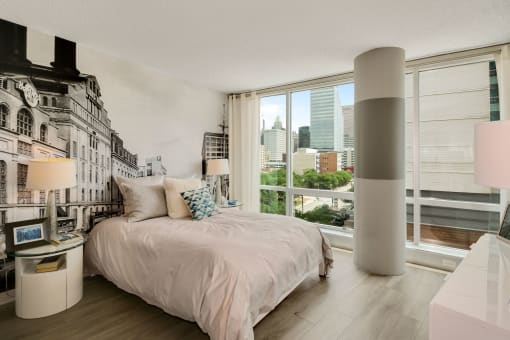 Spacious bedroom with floor to ceiling windows and a painted mural at The Zenith, Baltimore