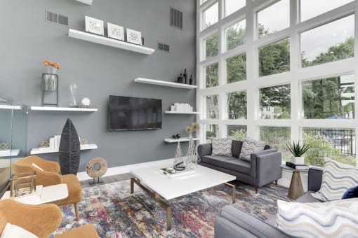 a living room with a large window and a tv on the wall at Madison at Eden Brook, Columbia, 21046