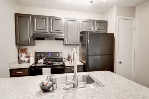 a kitchen with gray cabinets and white countertops at Hamilton at Kings Place, Columbia, MD 21046