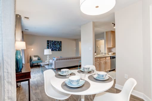 a dining area with a table and chairs and a kitchen in the background at Ellicott Grove, Ellicott City, 21043