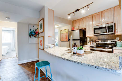 a kitchen with a granite counter top and stainless steel appliances at Ellicott Grove, Maryland