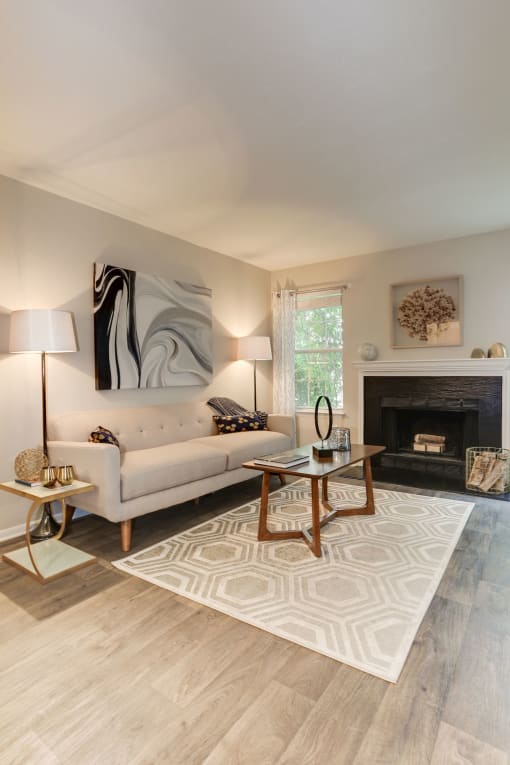 a living room with a couch coffee table and fireplace at Madison at Eden Brook, Columbia, MD 21046
