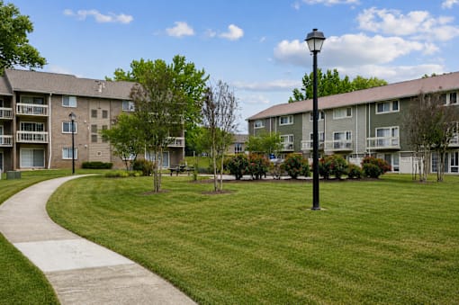 Spacious courtyard with walking path and lamppost at The Brook At Columbia Apartments, Columbia