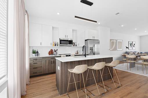 A modern kitchen with a bar stool in front of it.