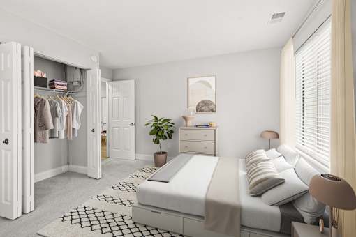 A white bedroom with a large bed, a wardrobe, and a potted plant  at Poplar Glen Apartments, Columbia, MD, 21044.