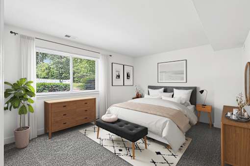 Modern bedroom with gray carpet and wood furniture at The Brook At Columbia Apartments, Maryland