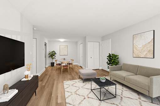 A living room with a black TV, a wooden floor, and a large painting on the wall  at Poplar Glen Apartments, Columbia, MD, 21044.