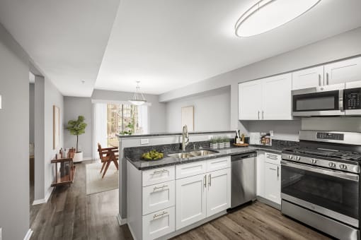 a renovated kitchen with white cabinets and stainless steel appliances at Villages at Morgan Metro, Landover, MD