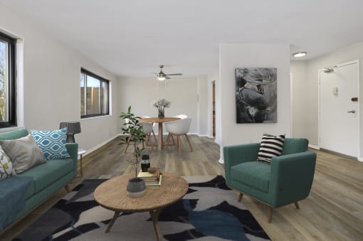 a living room with two green couches and a table with a chair at Earle Manor Apartments, Maryland, 20902