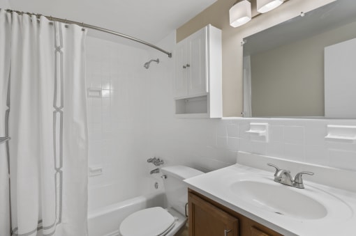 a white bathroom with a shower sink and toilet at Earle Manor Apartments, Wheaton, MD 20902