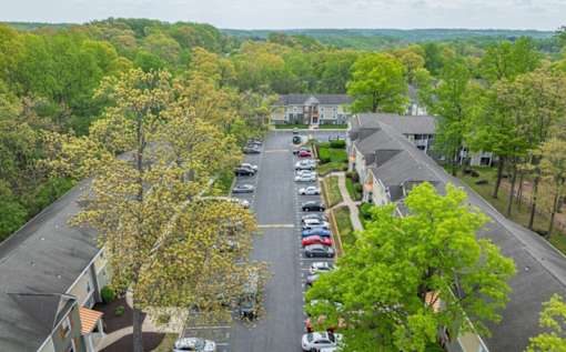A parking lot with cars and trees in the background at Ellicott Grove, Ellicott City, MD 21043