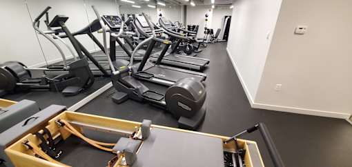 A gym with treadmills, elliptical machines and other cardio equipment.