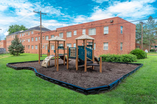 a playground in front of a brick building at Hamilton Manor Apartments, Hyattsville, 20782