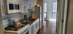 A kitchen with white cabinets and a stove top oven.