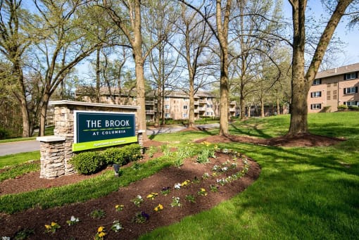 Community entrance monument sign with stone pillar at The Brook At Columbia Apartments, Columbia, 21044
