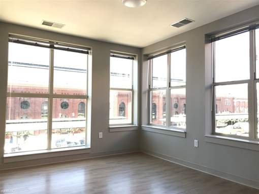 A room with large windows and wooden floors.