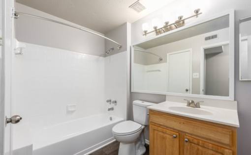 A white bathroom with a toilet, sink, and bathtub at Madison at Eden Brook, 21046