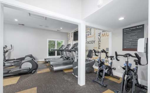 A gym with treadmills, exercise bikes, and a sign that says at Madison at Eden Brook, 21046