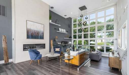 A living room with a fireplace and a painting on the wall at Madison at Eden Brook, 21046