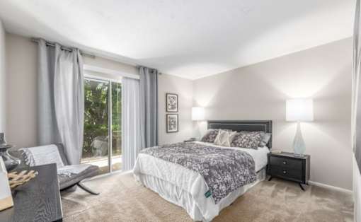 A bedroom with a large bed and a window with curtains at Madison at Eden Brook, 21046