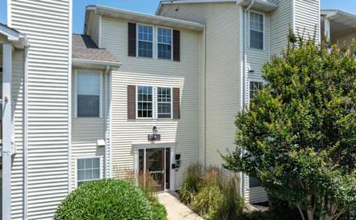 A white house with a brown door and windows at Madison at Eden Brook, 21046