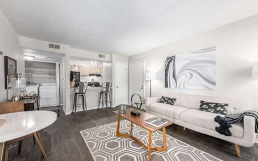 A modern living room with a white couch and a coffee table at Madison at Eden Brook, 21046