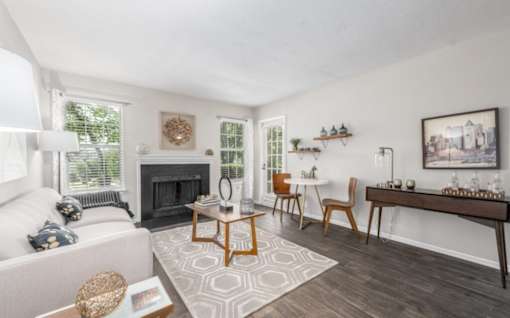 A living room with a fireplace and a white couch at Madison at Eden Brook, 21046