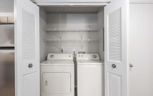 A white laundry room with a washer and dryer at Madison at Eden Brook, 21046