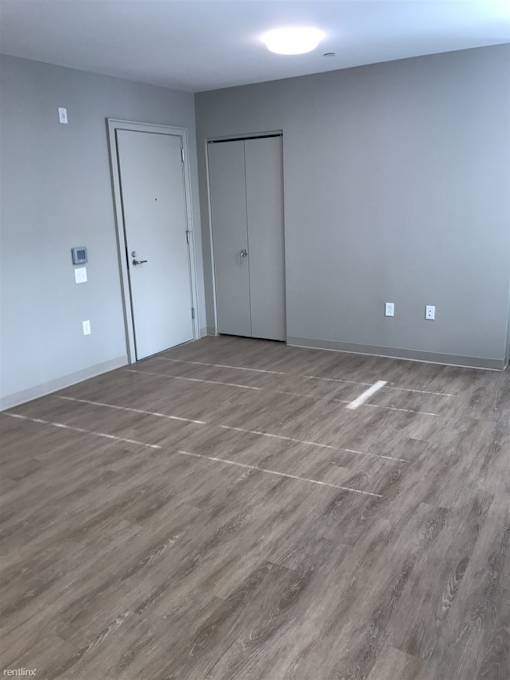 A room with grey walls and a grey floor with a white line in the middle.