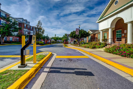 an empty street in a town with buildings and a street sign at MetroPlace at Town Center, Camp Springs
