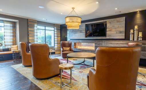 A living room with a fireplace and leather chairs at Mira Upper Rock, Maryland, 20850