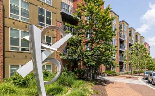 A large white sculpture in front of apartment buildings at Mira Upper Rock, Maryland, 20850