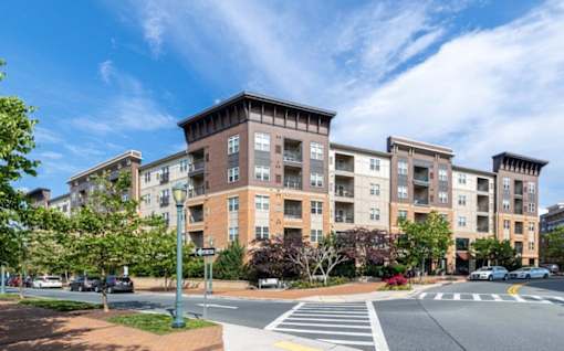 A large apartment building with a crosswalk in front of it at Mira Upper Rock, Maryland, 20850