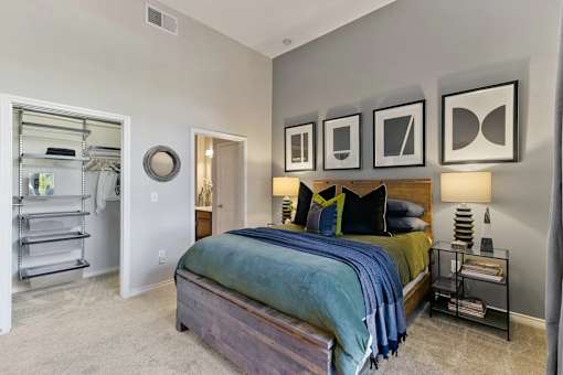 A bedroom with a bed, a nightstand, and a wall with picture frames at Prairie Crossing, Texas