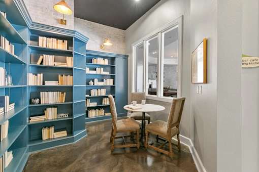 A room with a table and chairs and a bookshelf at Prairie Crossing, Farmers Branch, 75244