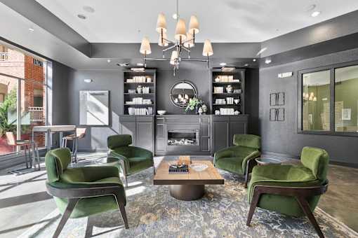 A modern living room with green chairs and a fireplace at Prairie Crossing, Farmers Branch, TX