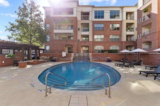 A pool in a courtyard surrounded by apartment buildings at Prairie Crossing, Farmers Branch, TX 75244