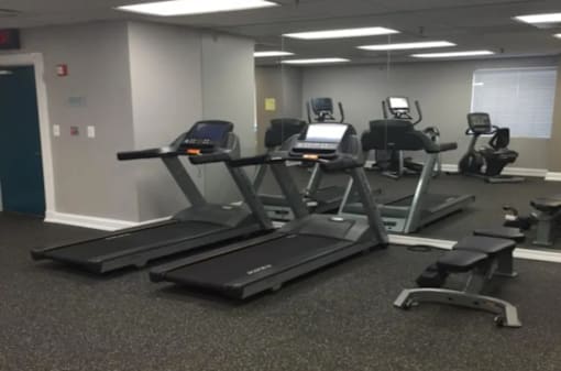 A gym with treadmills and elliptical machines.