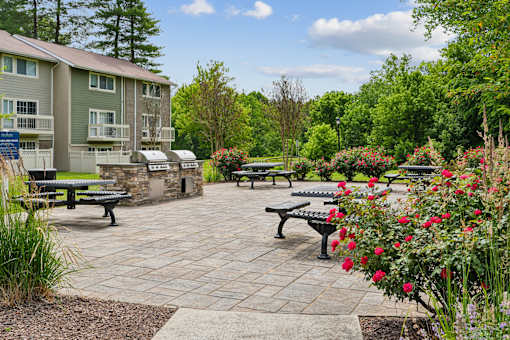 Outdoor patio with built in grills and benches at The Brook At Columbia Apartments, Maryland, 21044