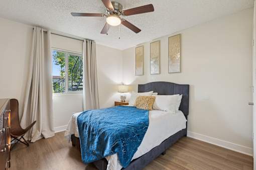 A bedroom with a bed, chair, and window at Riviera Park, Chandler Arizona