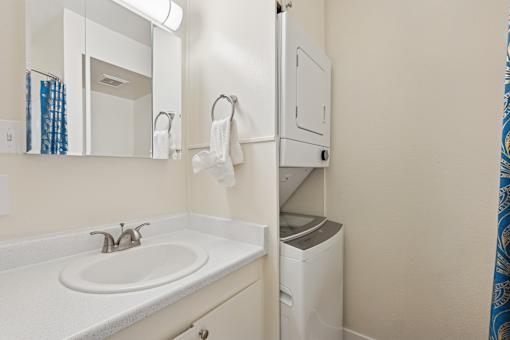 A bathroom with a white sink and a white trash can at Riviera Park, Chandler Arizona