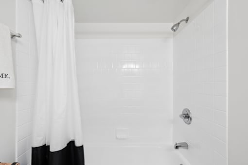 White subway tile bathroom with shower and tub at The Brook At Columbia Apartments, Maryland, 21044