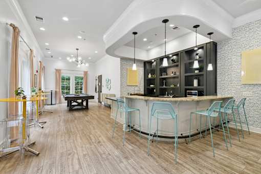 A modern bar area with a curved counter and blue chairs  at Poplar Glen Apartments, Columbia, MD, 21044.