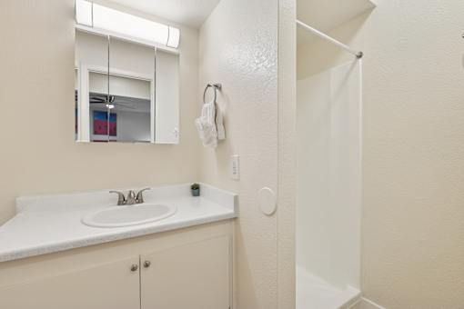 A white bathroom with a sink and mirror at Riviera Park, Chandler Arizona