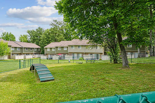 Enclosed dog park with agility equipment and benches at The Brook At Columbia Apartments, Columbia, MD 21044