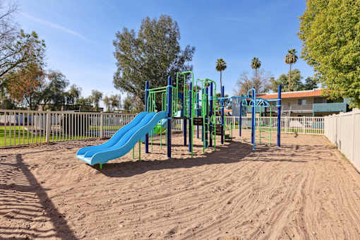 A playground with a blue slide and green monkey bars at Riviera Park, Chandler Arizona