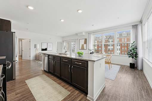 A kitchen with dark wood floors and white walls.