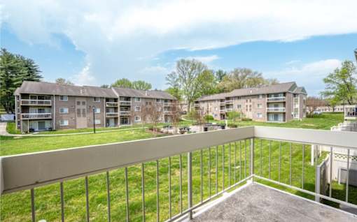 Balcony overlooking courtyard with apartment buildings at The Brook At Columbia Apartments, Columbia, MD 21044