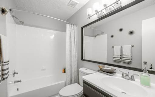 A white bathroom with a toilet, sink, and bathtub.
